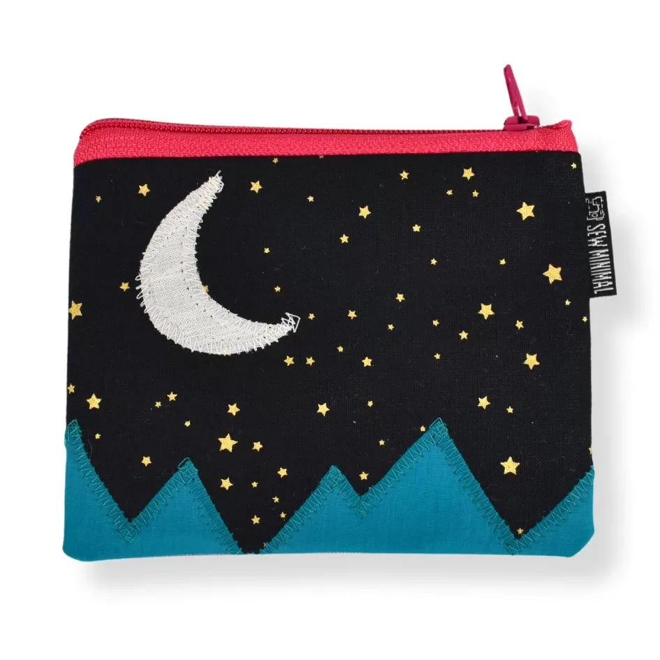 A small, black coin pouch with a crescent moon and mountain applique.