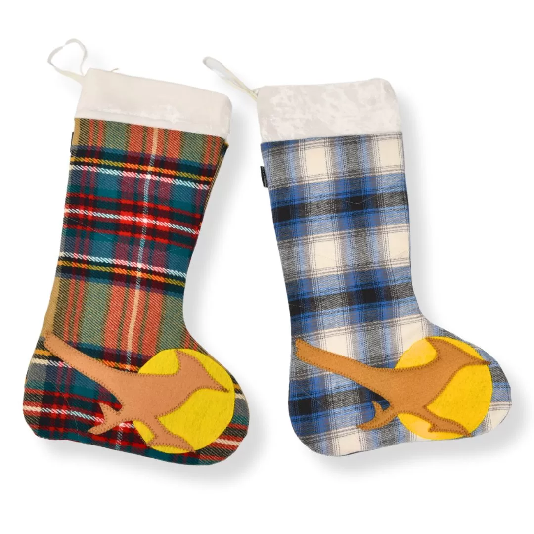 Two handmade Christmas stockings crafted from upcycled textiles. The left stocking is a brown plaid print and the right stocking is blue plaid. Each stocking has a brown roadrunner and yellow such applique design.